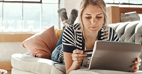 Woman holding card and tablet