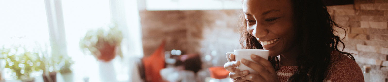 Woman sipping coffee in kitchen