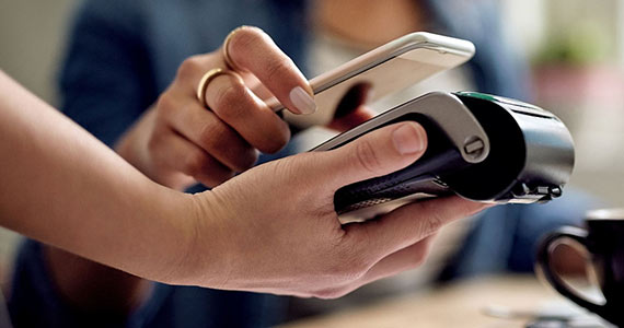 Woman paying by touching phone to reader