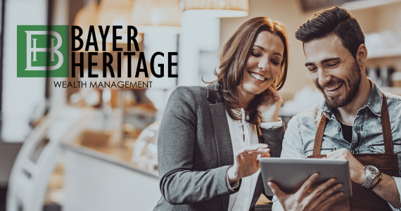 Bayer Heritage Wealth Management logo on image of woman helping small business owner in bakery.